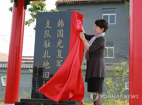 中國政府在西安韓國光復軍第二支隊駐地舊址設立的紀念碑29日上午10時正式揭幕，陜西省副省長王麗霞、韓國報勛處處長樸勝椿等共同出席了揭幕儀式。圖為王麗霞為紀念碑揭幕。(圖片來源：韓聯(lián)社)