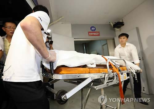 　警員正在搬運疑為俞炳彥的遺體。（韓聯(lián)社）