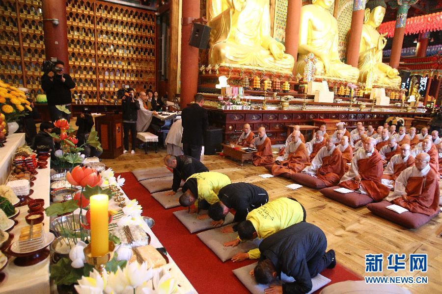 4月14日，在韓國(guó)首爾曹溪寺，“歲月”號(hào)沉船事故遇難者家屬在法會(huì)上祭奠親人。