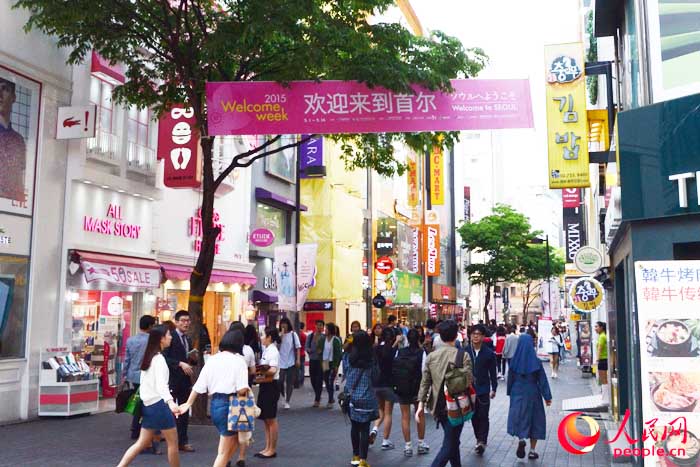 走入明洞主路，首先映入眼簾的便是這樣一條歡迎橫幅。（攝影：王昱祺）