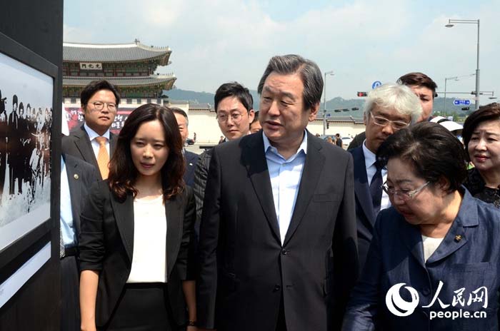 韓國執(zhí)政黨新國家黨黨首金武星（中）、國會議員金乙東（右）、人民網(wǎng)韓國公司負(fù)責(zé)人周玉波（左）在觀看圖片展。（攝影：張悅）