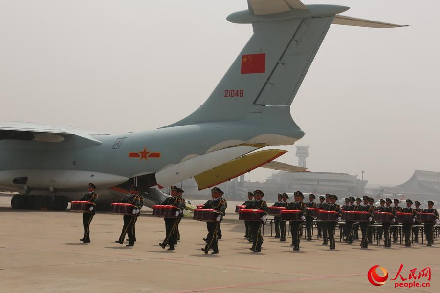 禮兵護(hù)送志愿軍烈士遺骸棺槨至棺槨擺放區(qū)。李祥輝攝