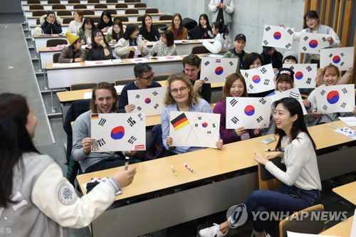 資料圖片：2月27日，在首爾明知大學(xué)人文校區(qū)，外國(guó)人留學(xué)生手繪韓國(guó)國(guó)旗。（韓聯(lián)社/明知大學(xué)供圖）