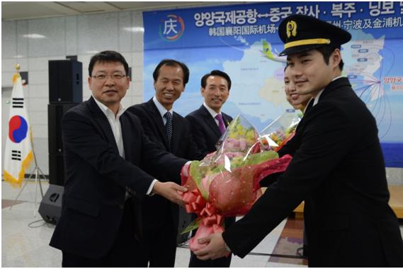 12月4日在襄陽國際機場舉行的真航空襄陽-長沙開航儀式上，江原道知事崔文洵（左中）、真航空總經(jīng)理馬元（左一）、韓國航空公司總經(jīng)理金碩基和真航空乘務(wù)員一起拍照留念。