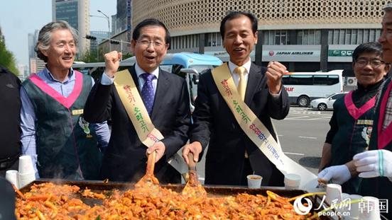 活動當(dāng)天，在首爾市政府廣場，江原道知事崔文洵與首爾市長樸元淳親手給市民制作春川烤雞。